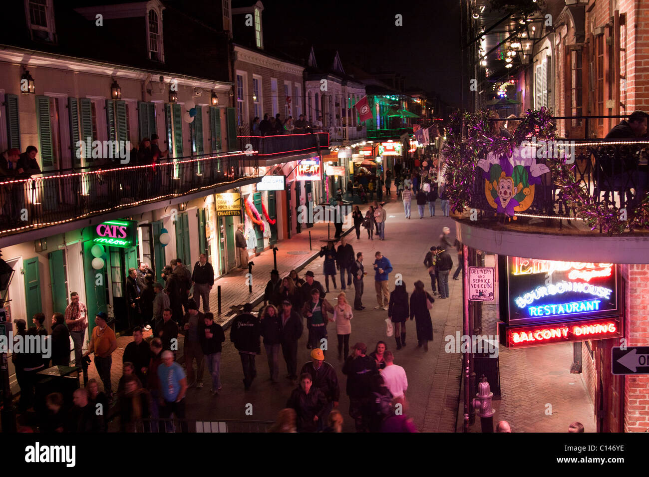 Aerial view of Bourbon Street in New Orleans, with people drinking and walking by neon signs for bars and clubs at night Stock Photo