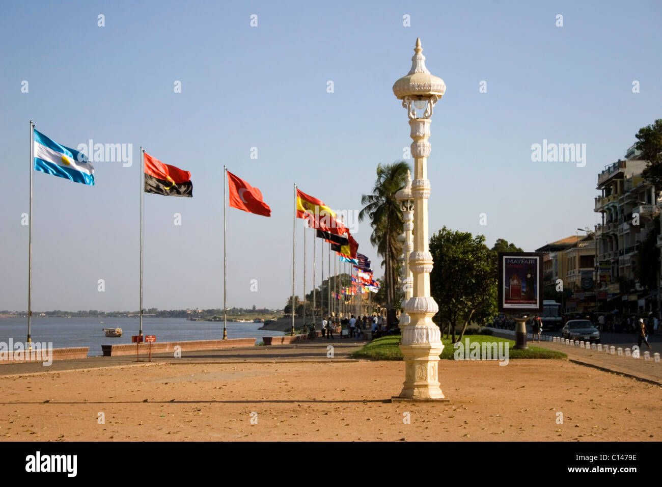 A group of international flags are flying in the wind on the riverside promenade near the Mekong River in Phnom Penh, Cambodia. Stock Photo