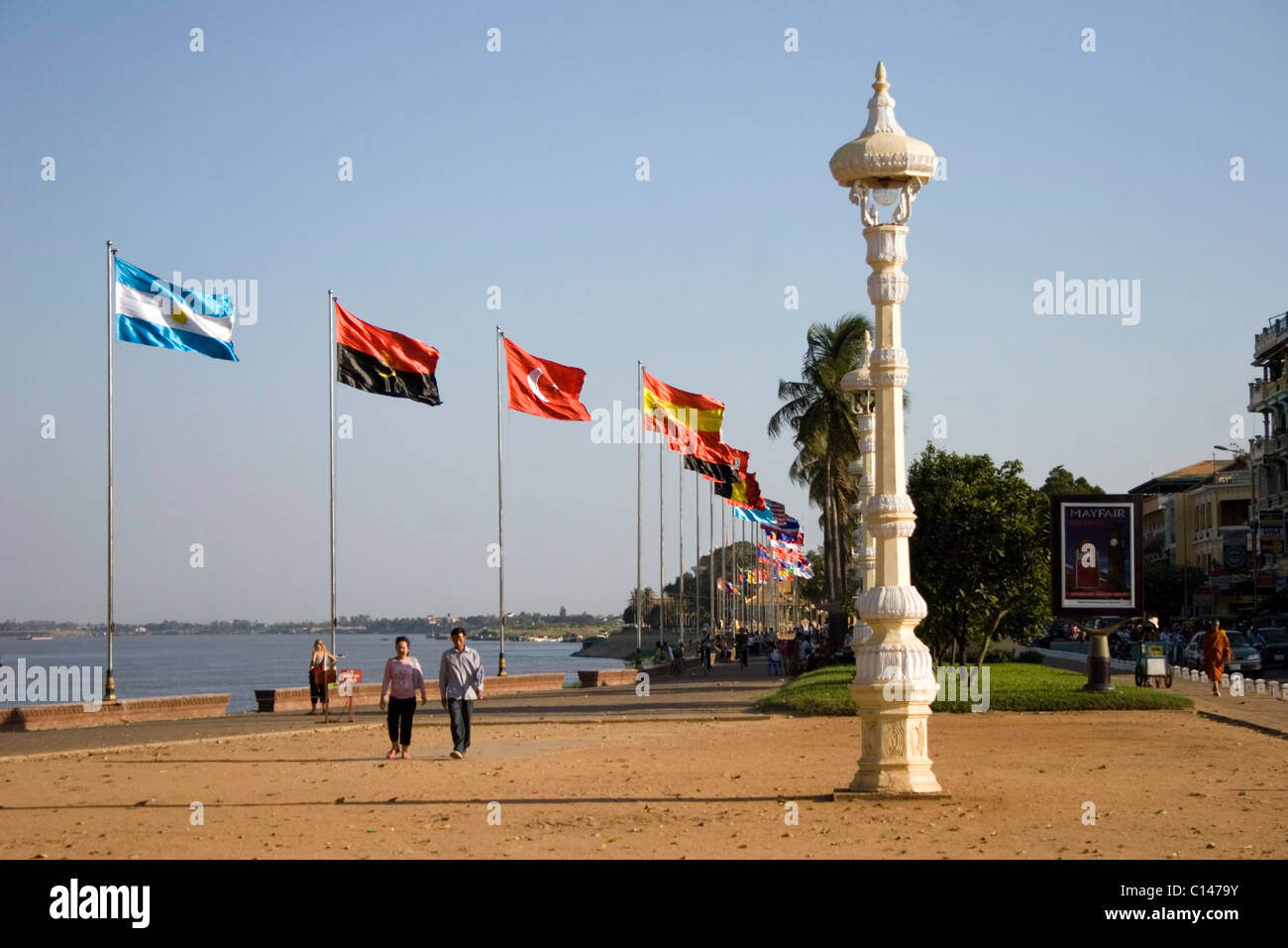 A group of international flags are flying in the wind on the riverside promenade near the Mekong River in Phnom Penh, Cambodia. Stock Photo