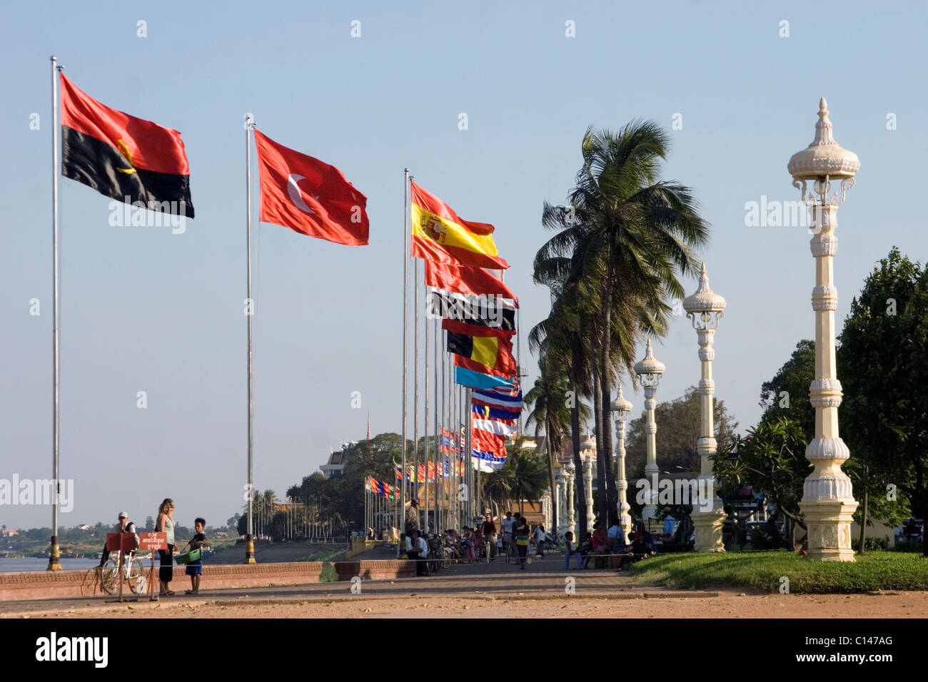 A group of international flags are flying in the wind on the riverside promenade near the Mekong River in Phnom Penh, Cambodia. Stock Photo