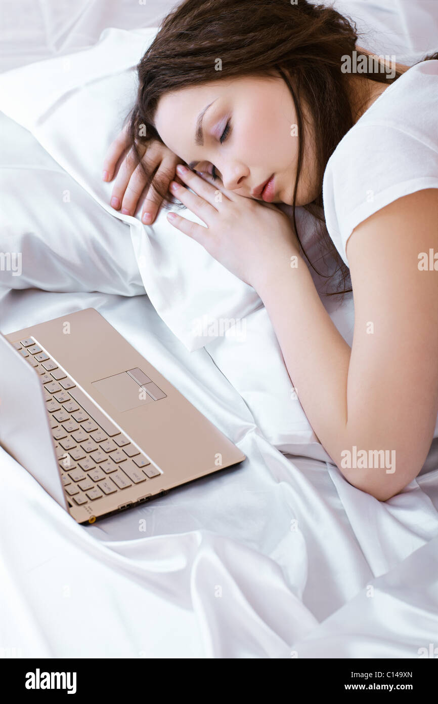 portrait of beautiful girl sleeping in bedroom on linen with notebook