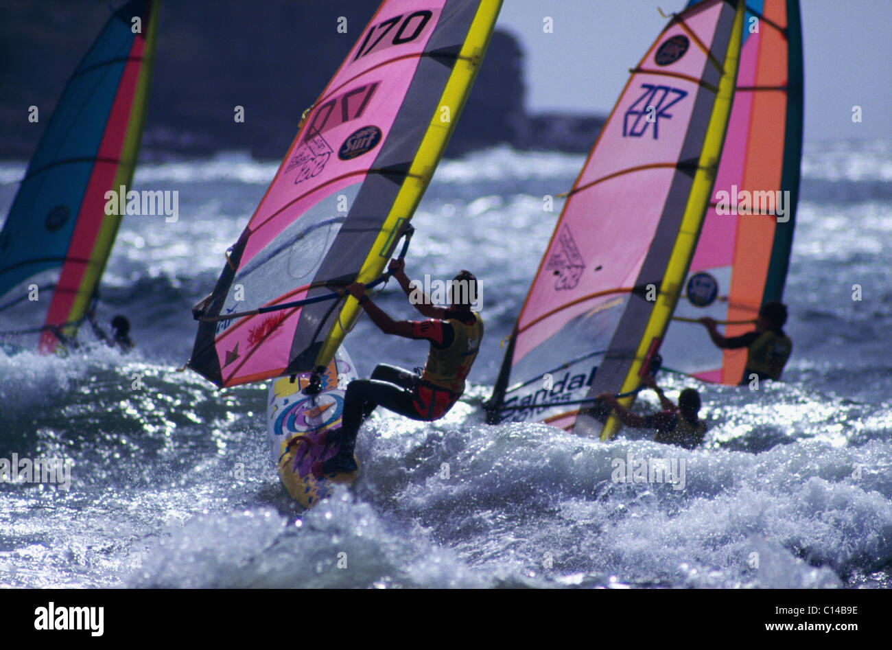Group of windsurfers race out over  the waves in Marazion Bay Stock Photo