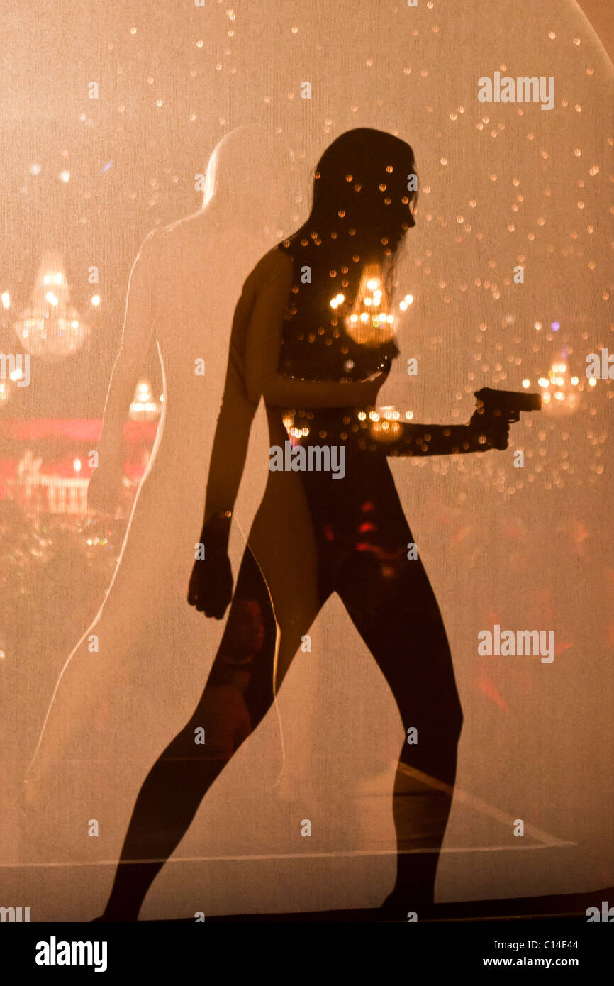Shadow of a woman holding a gun at a James Bond theme party Stock Photo