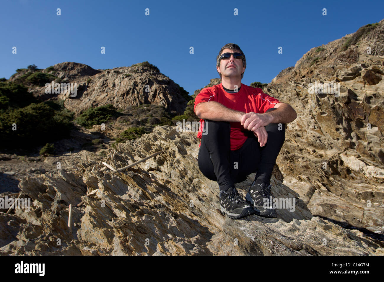 Man sitting on rocks Stock Photo - Alamy
