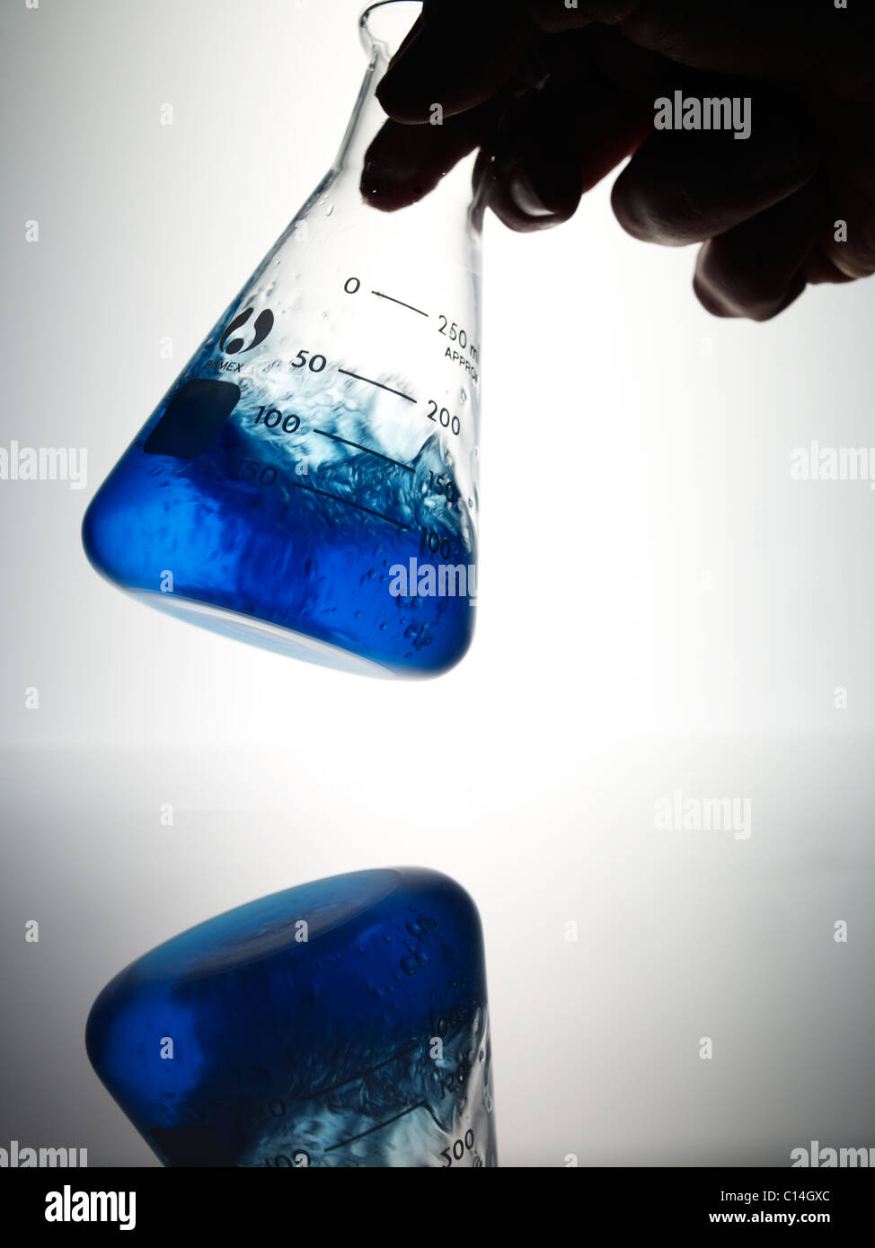 Science lab flask on a white background the flask contains a clear blue ...