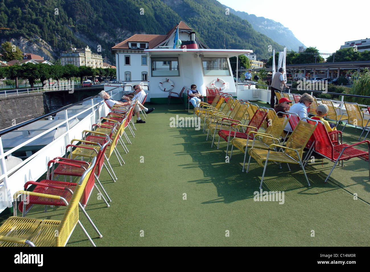 The upper deck and the easy chairs for relaxation (along with the people on the first class upper deck) of the small cruise ship on Lake Thun Stock Photo