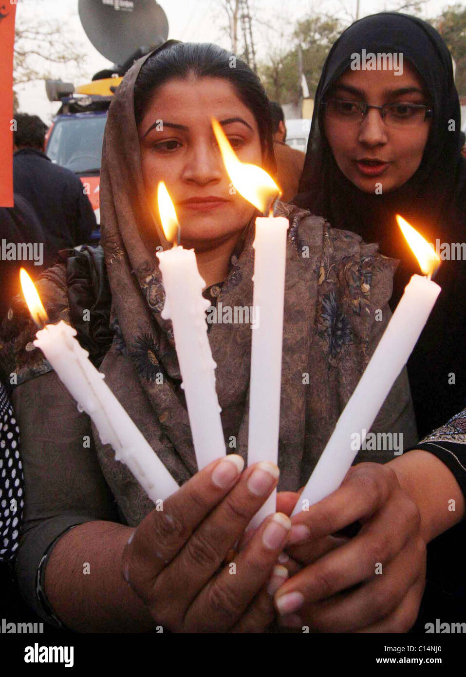 Supporter of Kashaf Foundation holds lightened candles during demonstration on occasion of the “World Women Day” in Lahore Stock Photo