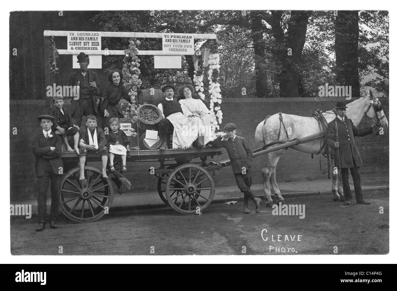 Original and clear Edwardian era postcard of Temperance Society campaigners (some characters) on a horse drawn cart or wagon with signs and dressed to show the perils of drink, possibly a carnival float, possibly from  Devon as the Cleave Photo could indicate (or could be the photographer's name), likely South West England, UK - circa 1910 Stock Photo