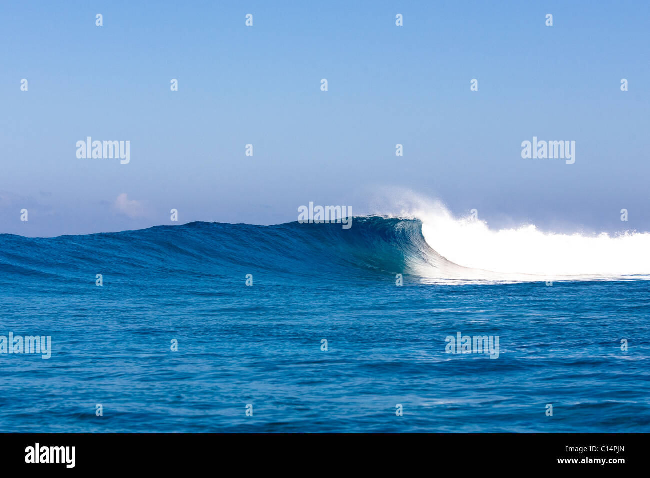 A large set wave breaks at Wilkes Pass in Namotu, Fiji. Stock Photo