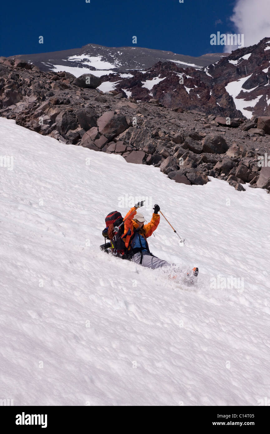 A mountaineer sliding or glissading down a snow covered mountain