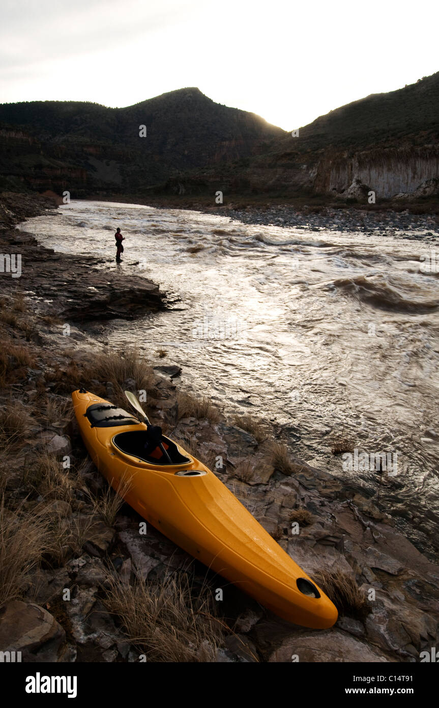 A whitewater kayak rests on the shore after a surf session in Ledge