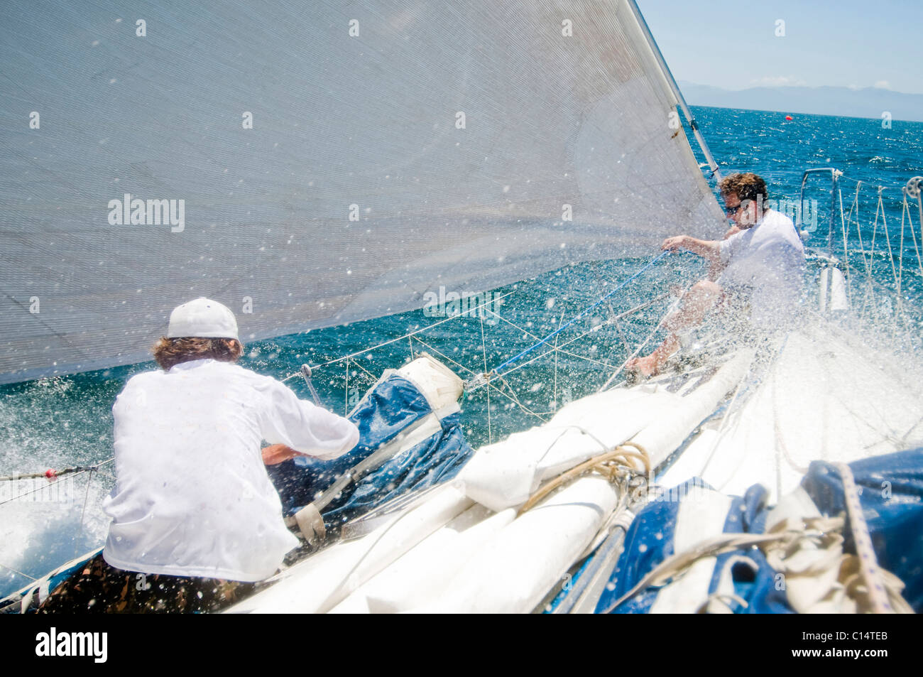 Two sailors preparing a sail during a race Stock Photo