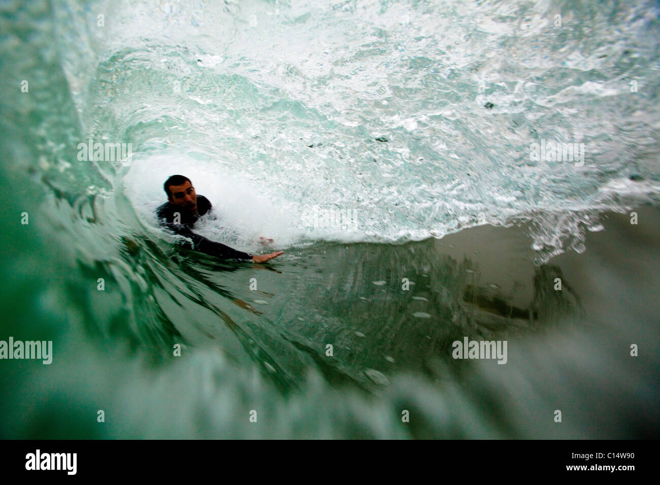 A male bodysurfer gets barreled while bodysurfing at Zuma beach in Malibu, California. Stock Photo