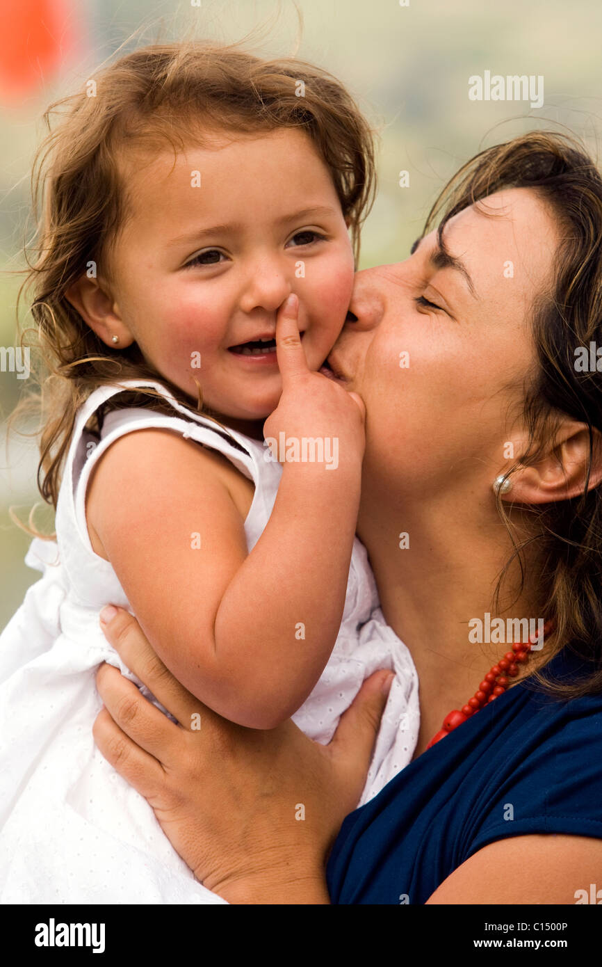 Young mother kissing her daughter - Cabanas Del Lago - Lake San Pablo, near Otavalo, Ecuador Stock Photo