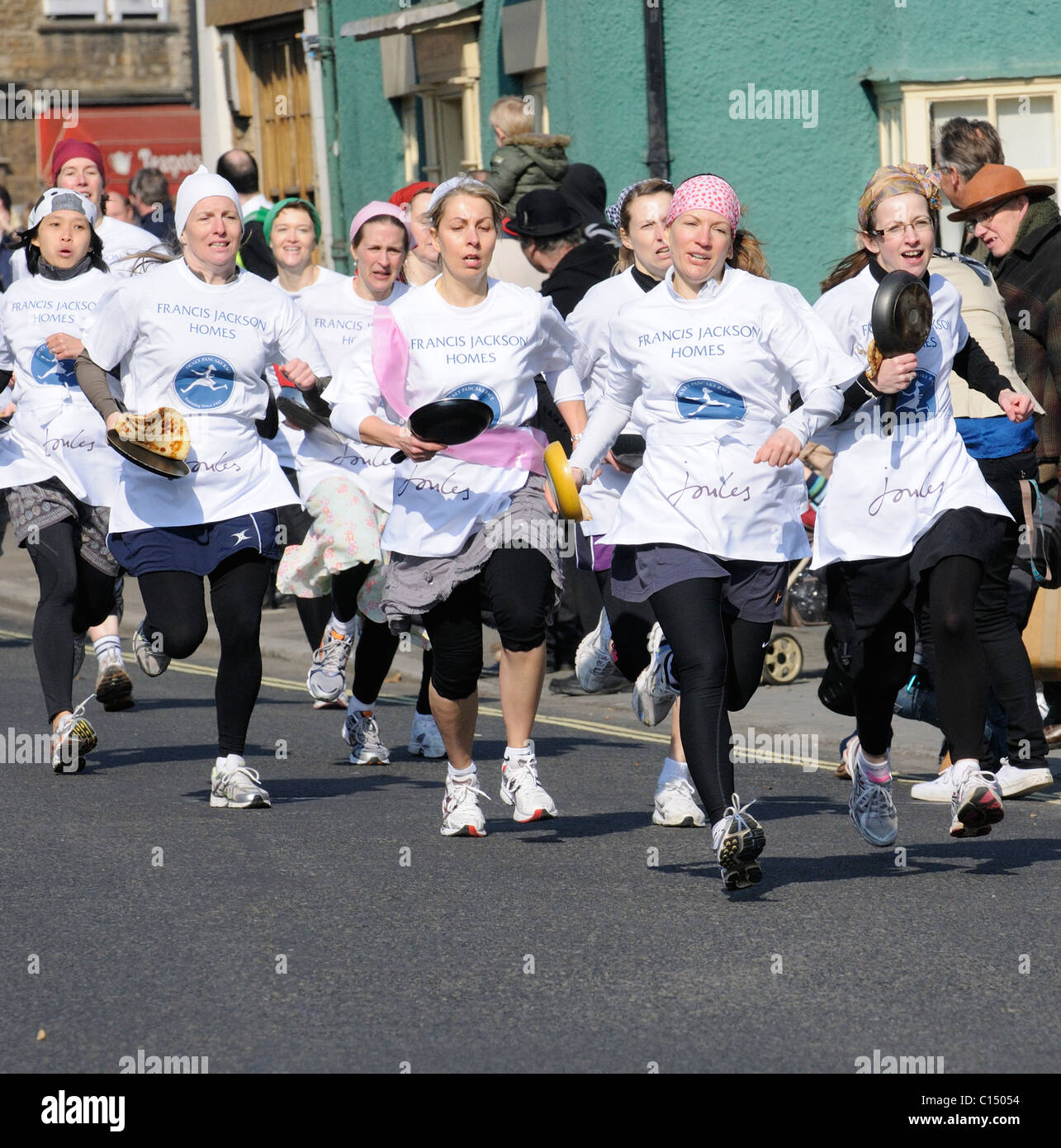 Pancake Race in Olney Buckinghamshire competitors race with their pans