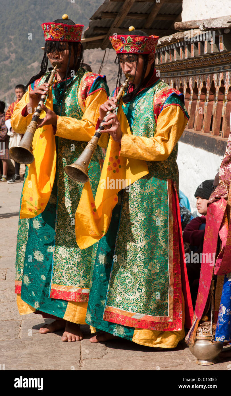 Bhutanese musicians who are actually monks play their horns to accompany a festival dance in Trongsa, Bhutan. Stock Photo