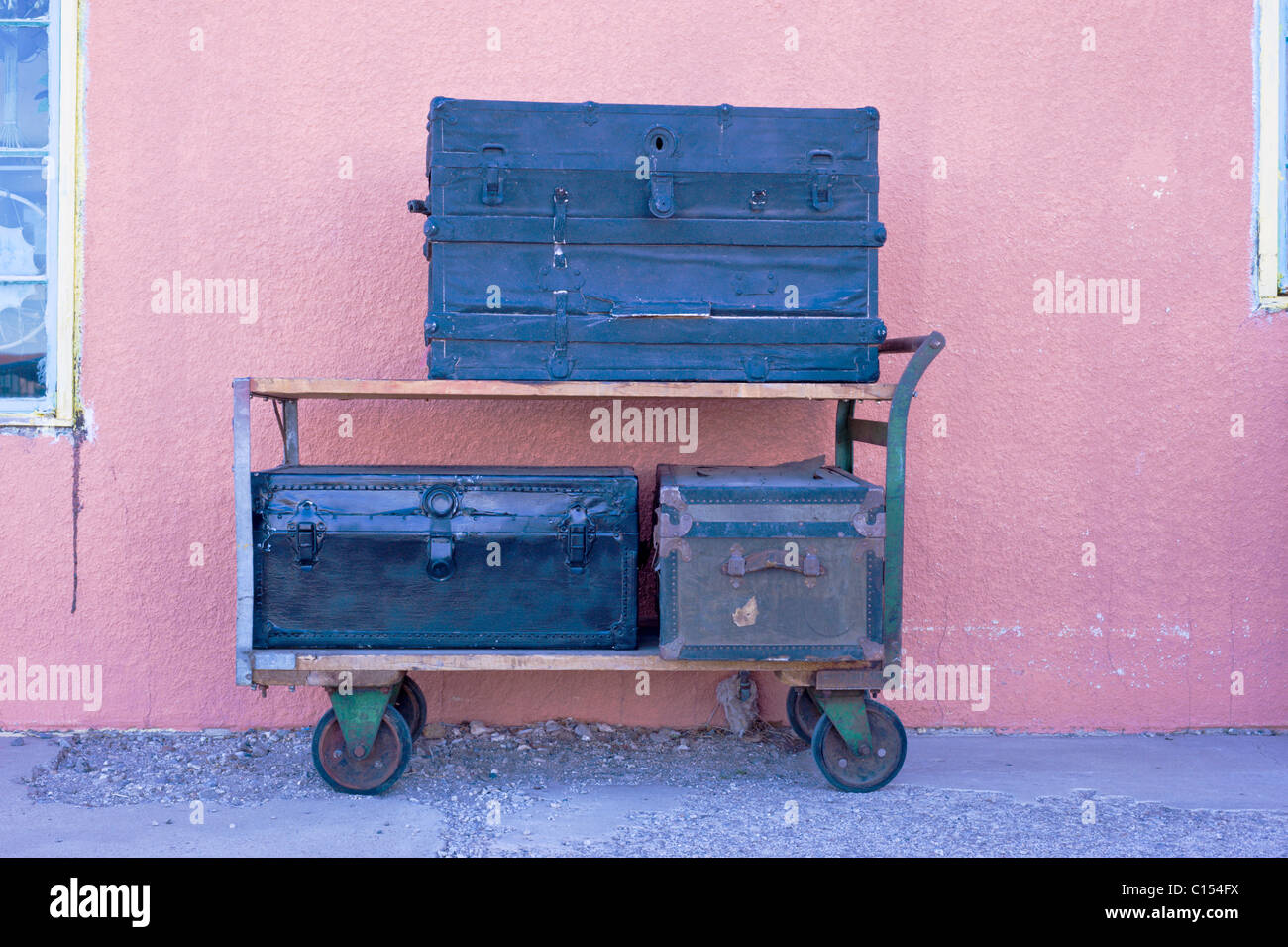 A rolling cart loaded with old, vintage, antique trunks stands outside a second-hand shop in Roswell, New Mexico. Stock Photo