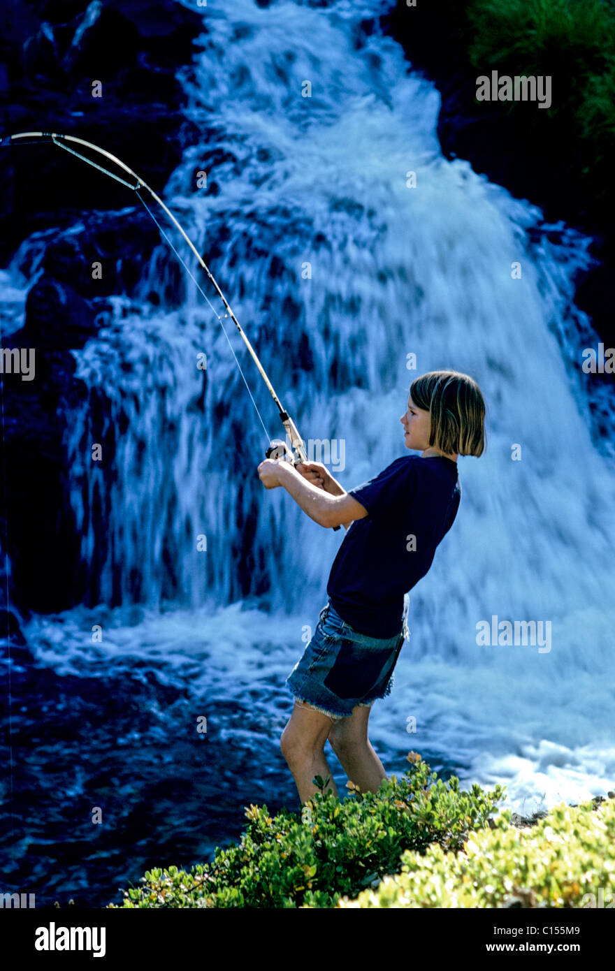 teenage boy fishing  at waterfall while on vacation in Lassen National Park. © Bob Kreisel Stock Photo