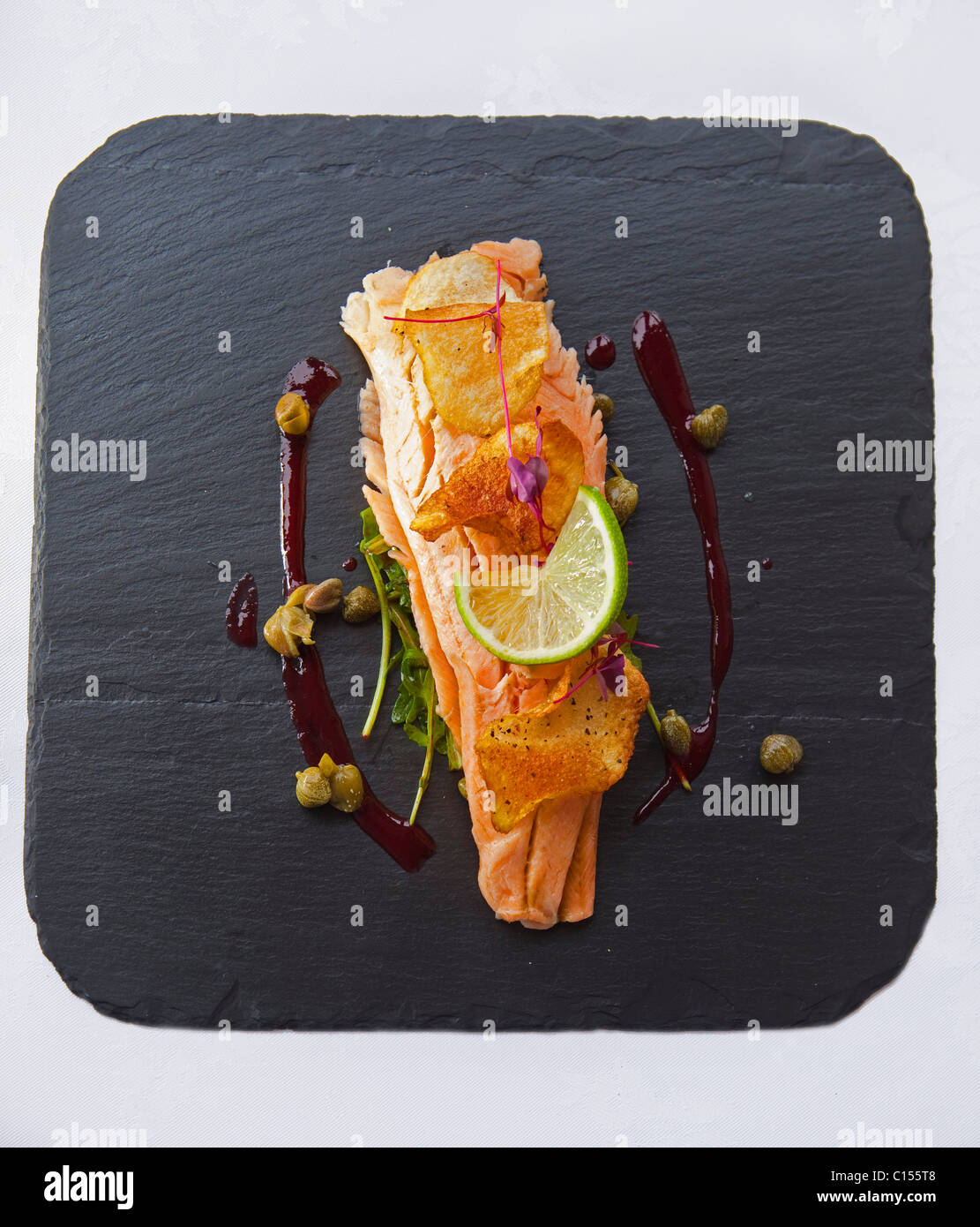 Starter warmed oak smoked trout fillet with a lemon caper and crisp potato salad and beetroot puree on slate 116362 Food06 Stock Photo