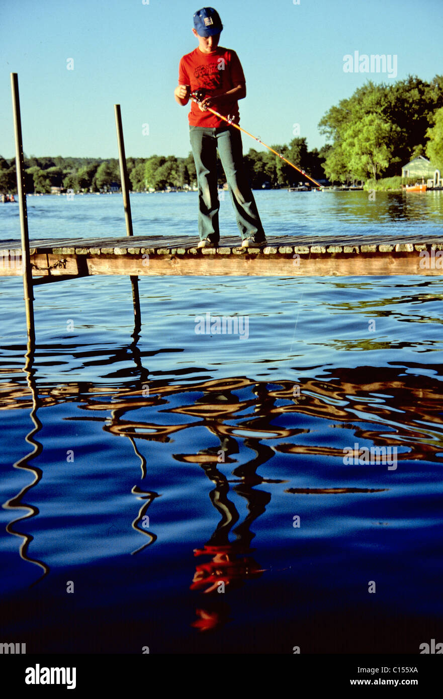 Boy fishing off dock - Stock Photo - Dissolve