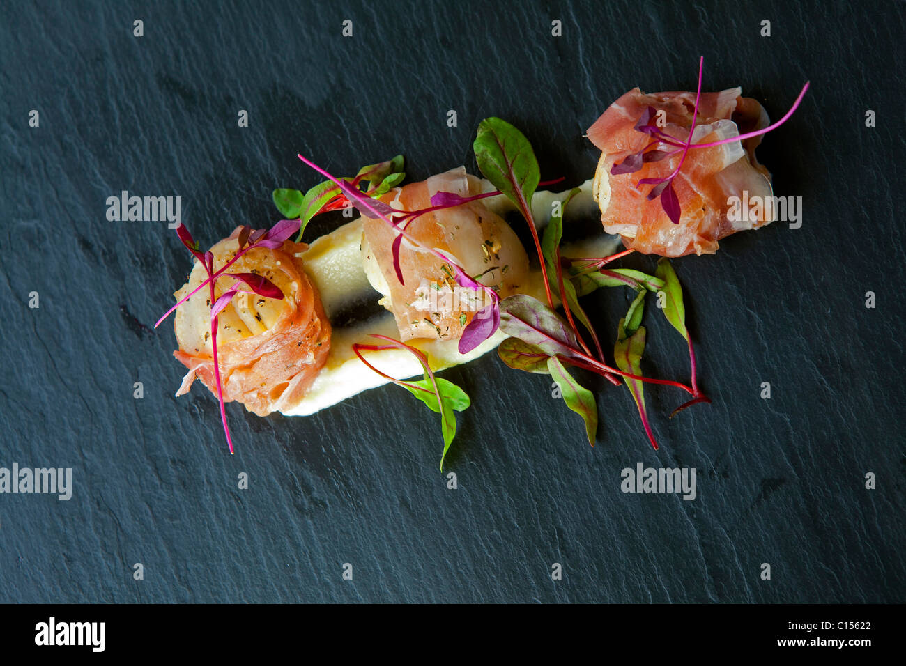 Starter pan fried king scallops and "Parma ham" served on a bed of