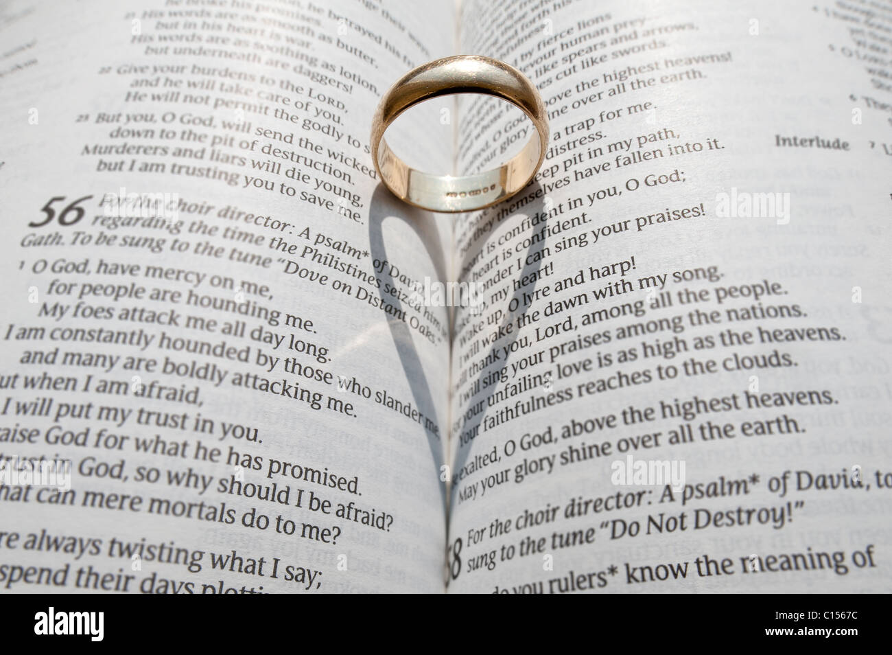 A wedding ring casting a shadow on the open pages of an open religious book  Stock Photo - Alamy