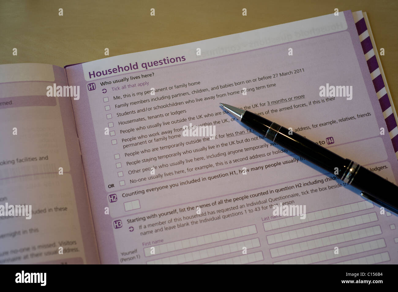 A close-up view of the 2011 UK Census form lying open on desk with a pen awaiting completion. Stock Photo