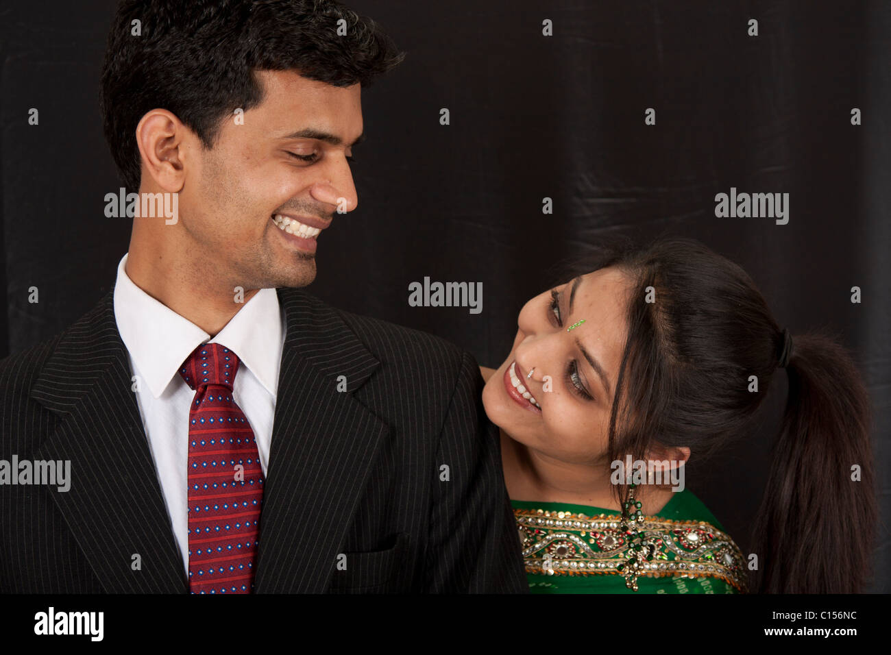 A young couple looking and smiling at each other after their engagement ceremony. Stock Photo