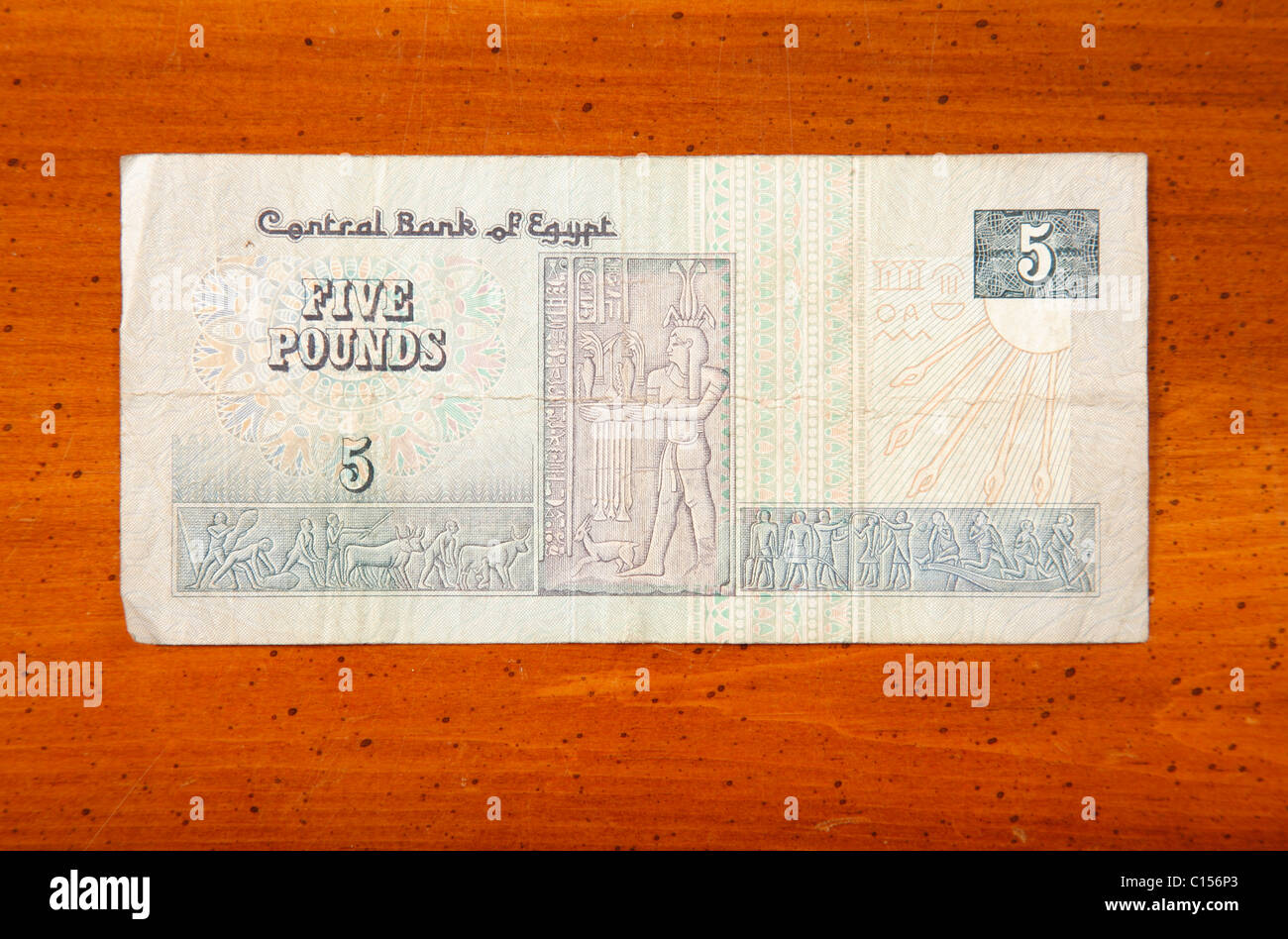 Egyptian 5 pound currency note on table with English script showing bass relief art Stock Photo