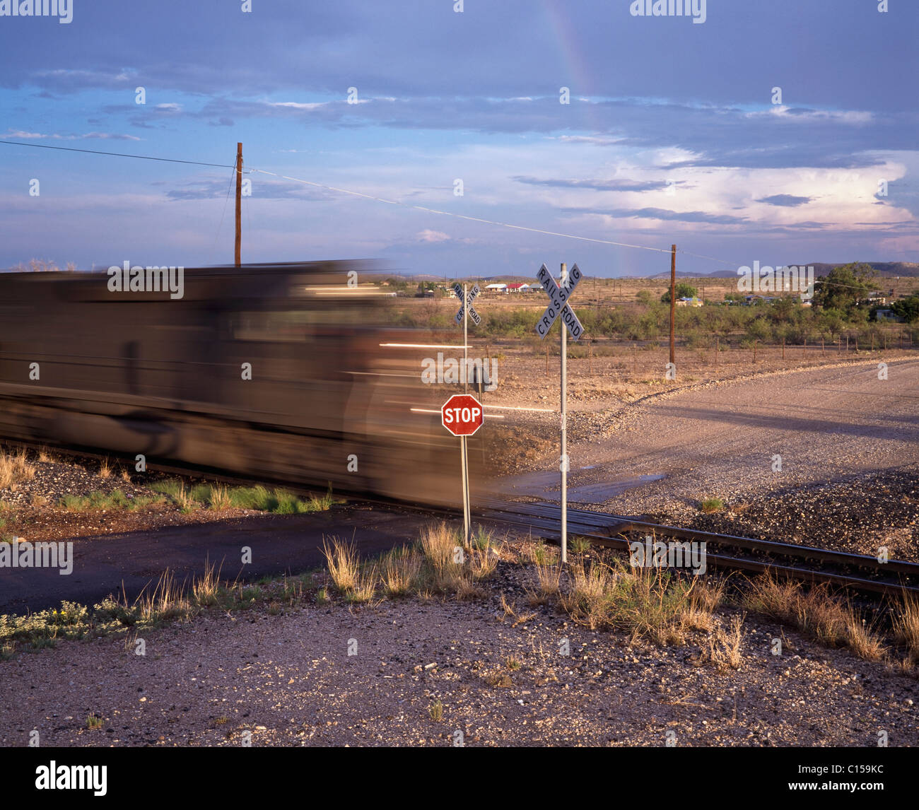 Blurred train on railroad crossing Stock Photo