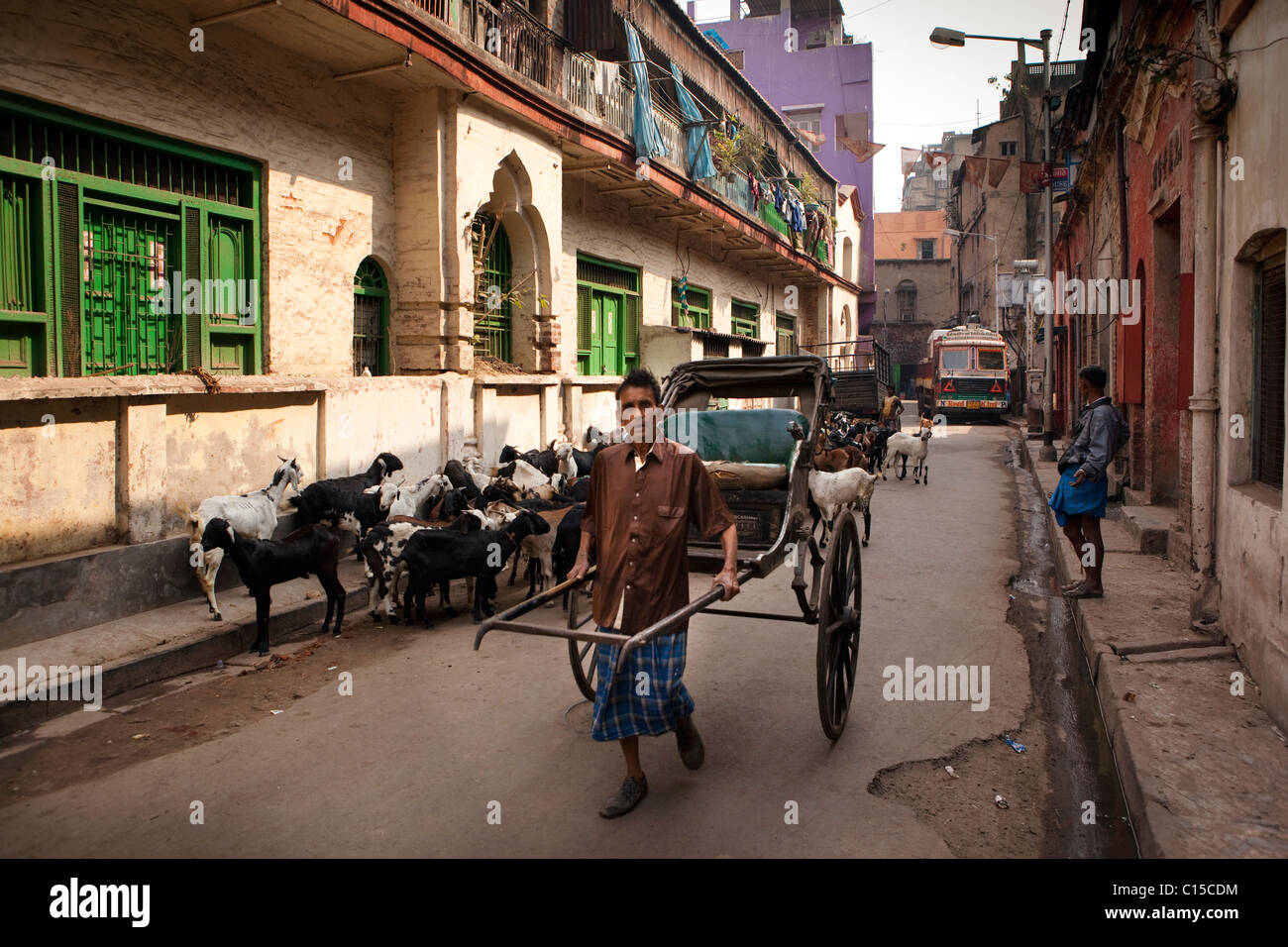 India, West Bengal, Kolkata, Calcutta, Old Chinatown, man pulling human-powered rickshaw Stock Photo