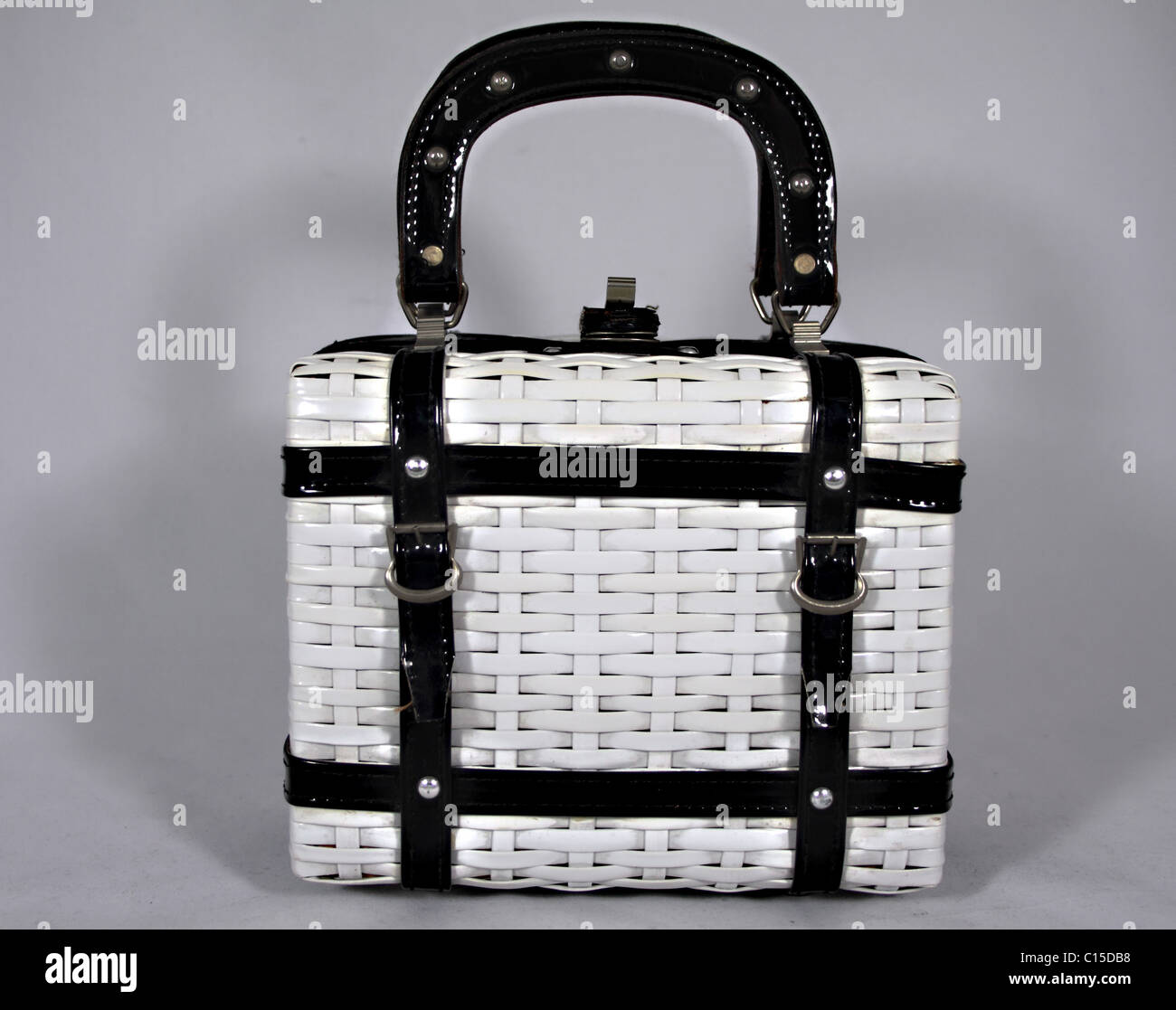 Black and white, plastic, basket weave style, vanity case. Handles are up and the lock is