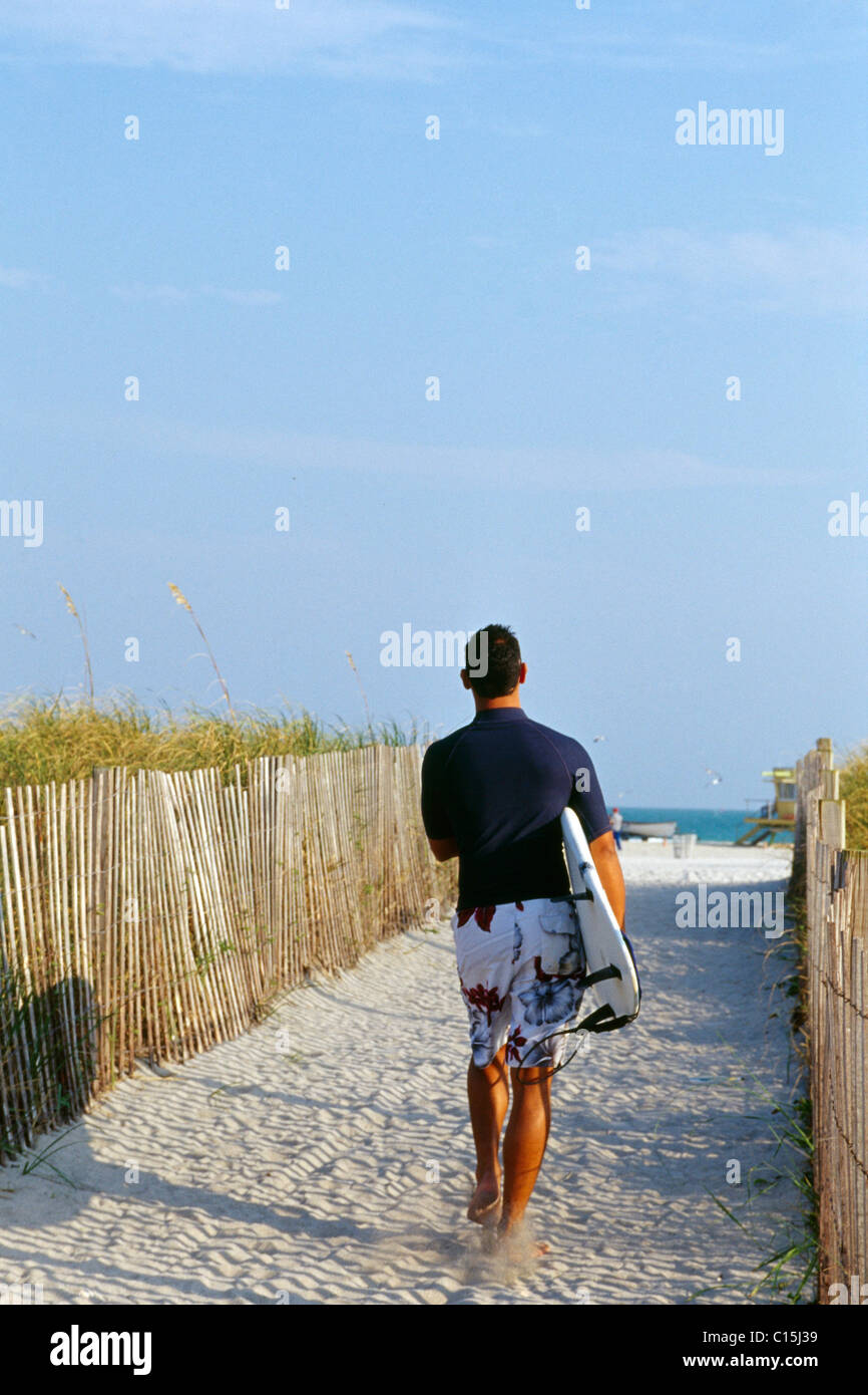 Surfer walking with his board under his arm, South Beach, Miami Beach, Miami, Florida, USA Stock Photo