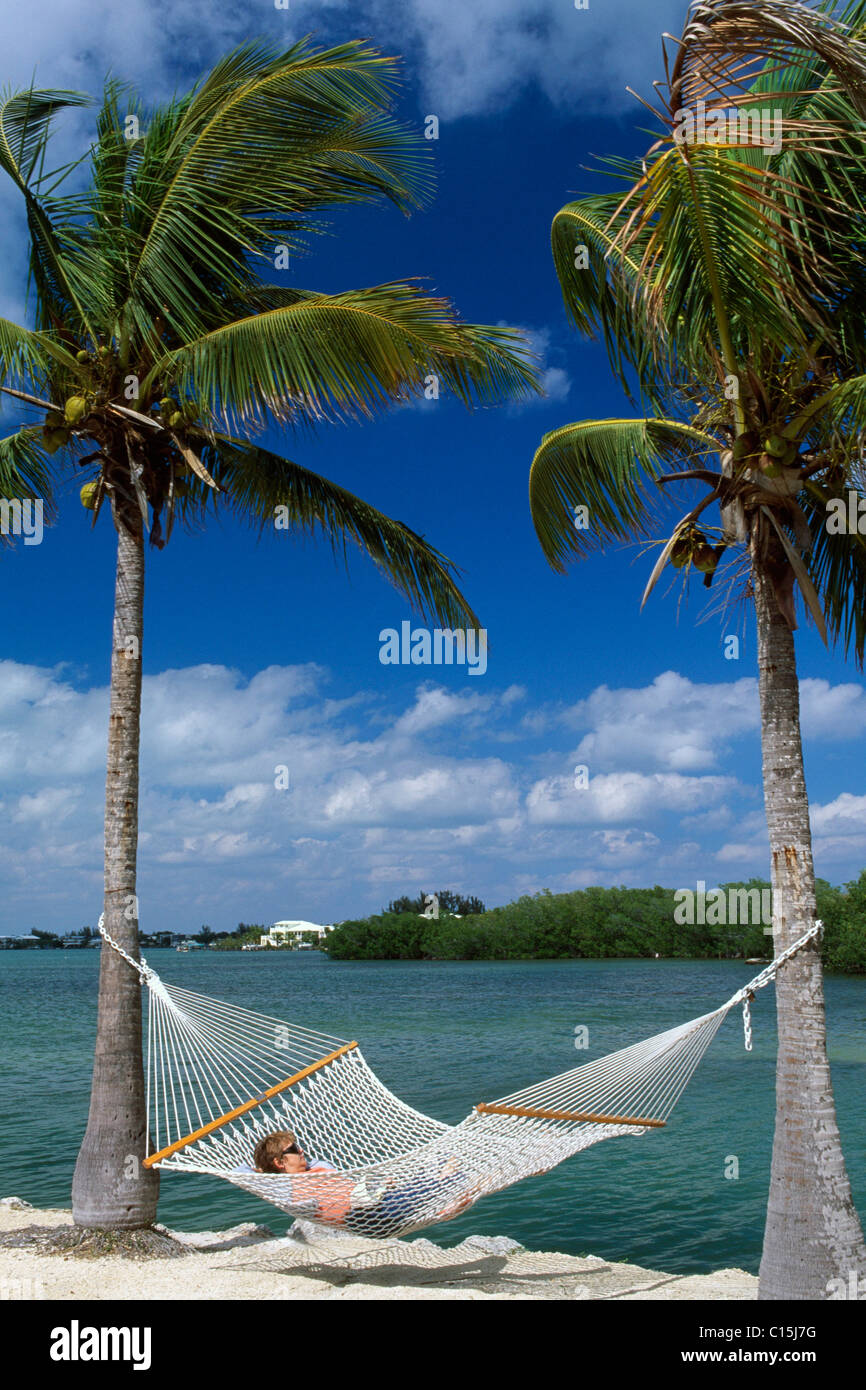 Woman lying on a hammock at the Garden Cove Resort, Key Largo, Florida Keys, Florida, USA Stock Photo