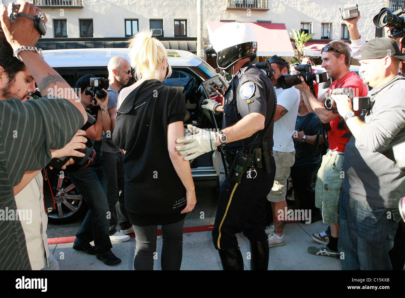Gwen Stefani is escorted by a police officer after shopping at the children's boutique Trico Field Los Angeles, California - Stock Photo