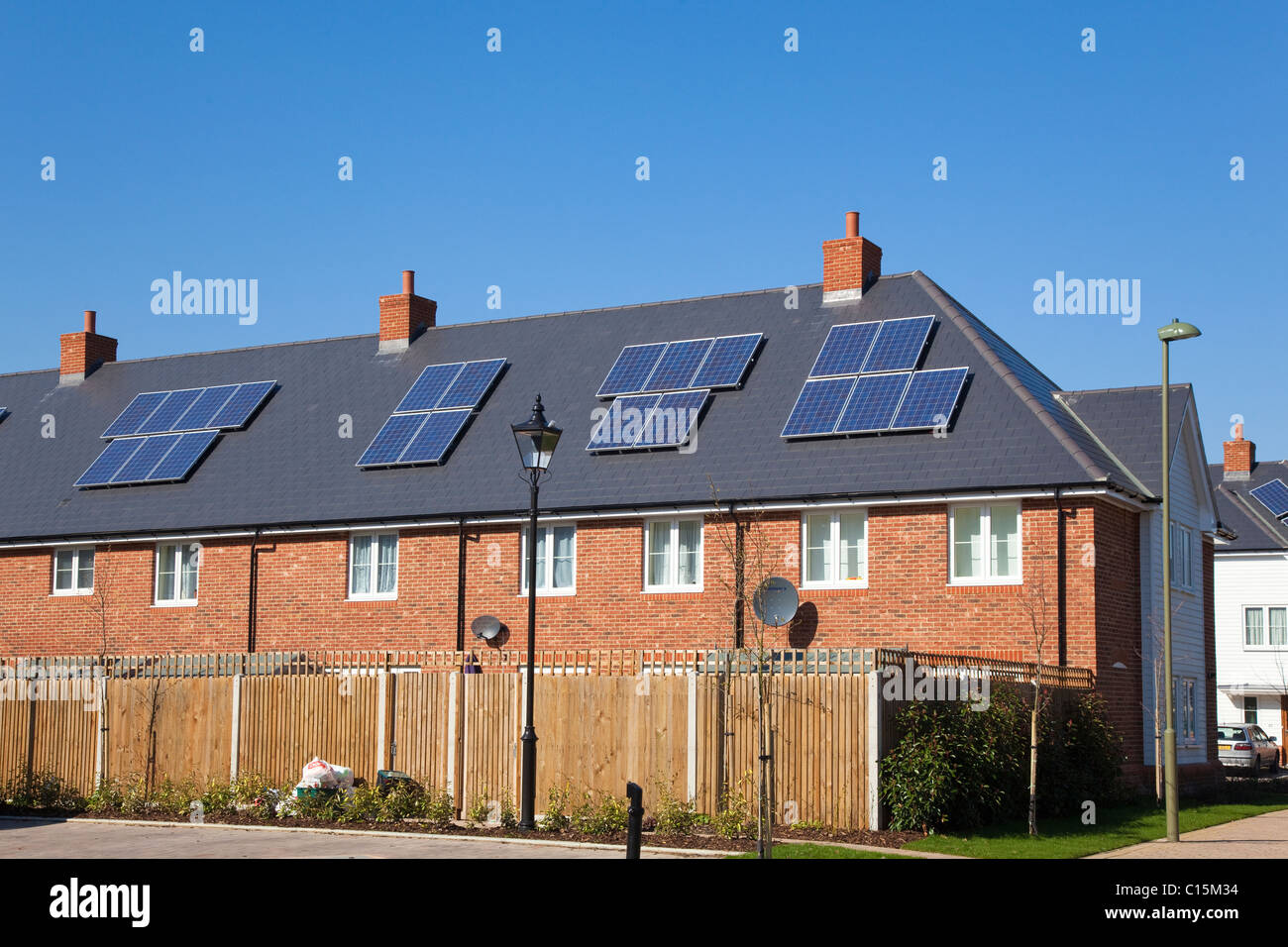 Solar or photovoltaic panels on a domestic roof with a blue sky, Kent