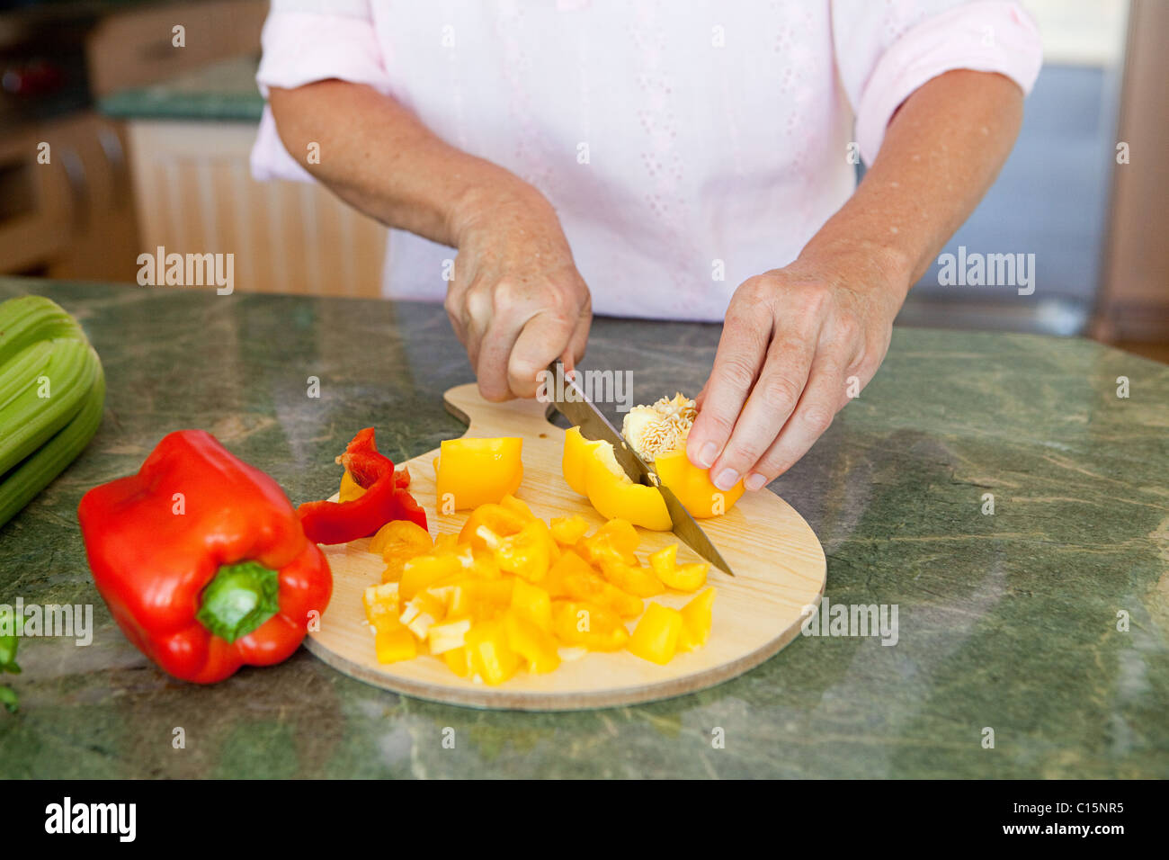 Woman chopping peppers on chopping board Stock Photo - Alamy
