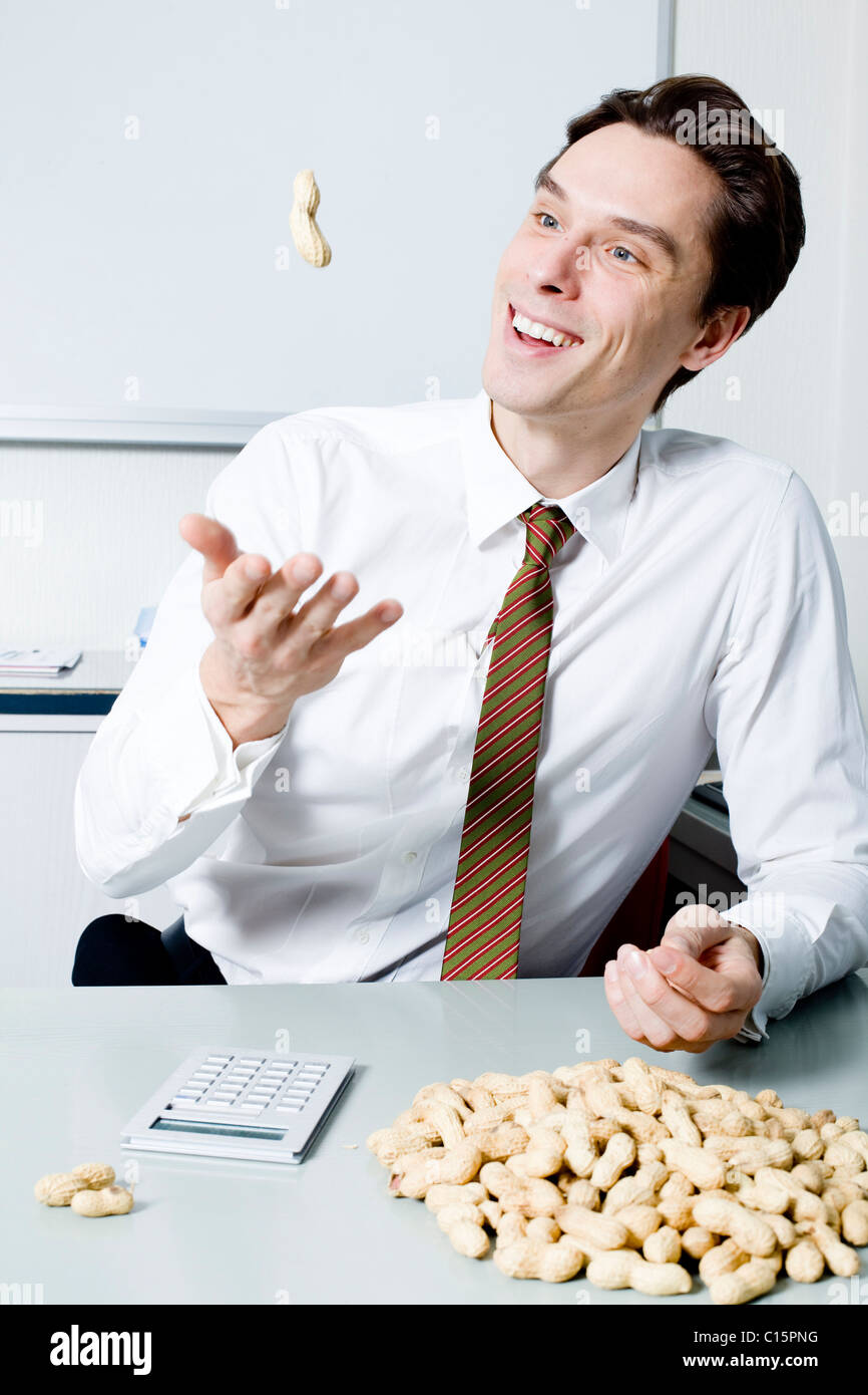 Businessman throwing peanut Stock Photo Alamy