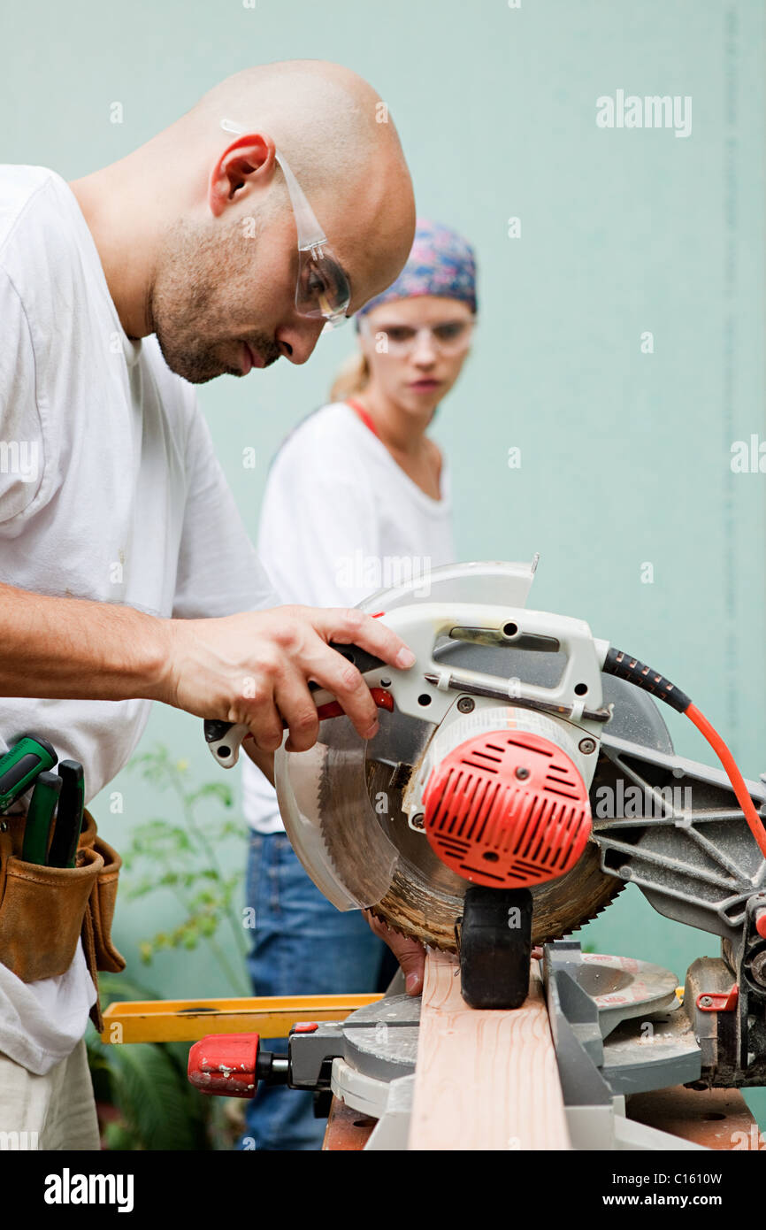 Couple using circular saw Stock Photo - Alamy