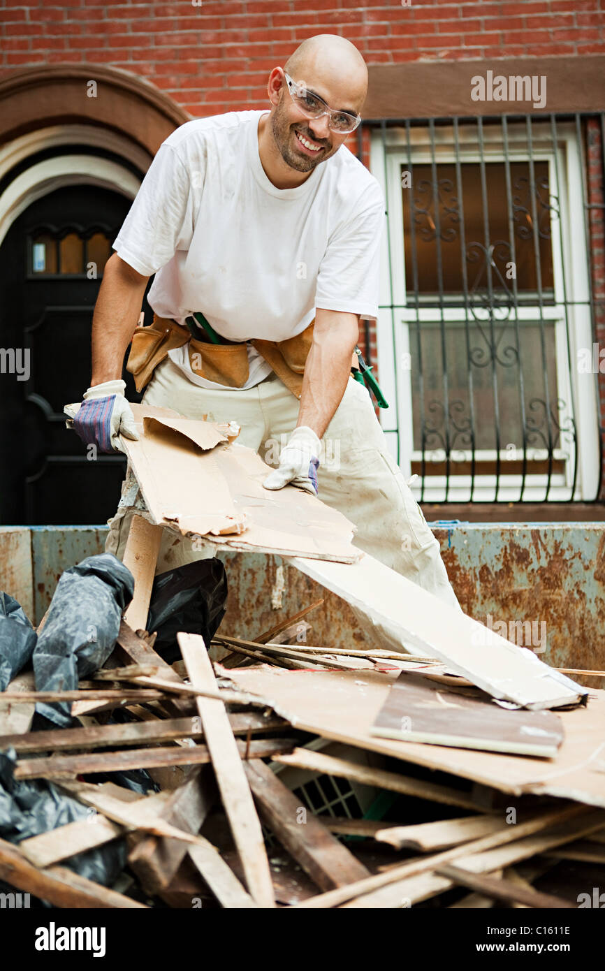Man filling skip with rubble Stock Photo Alamy