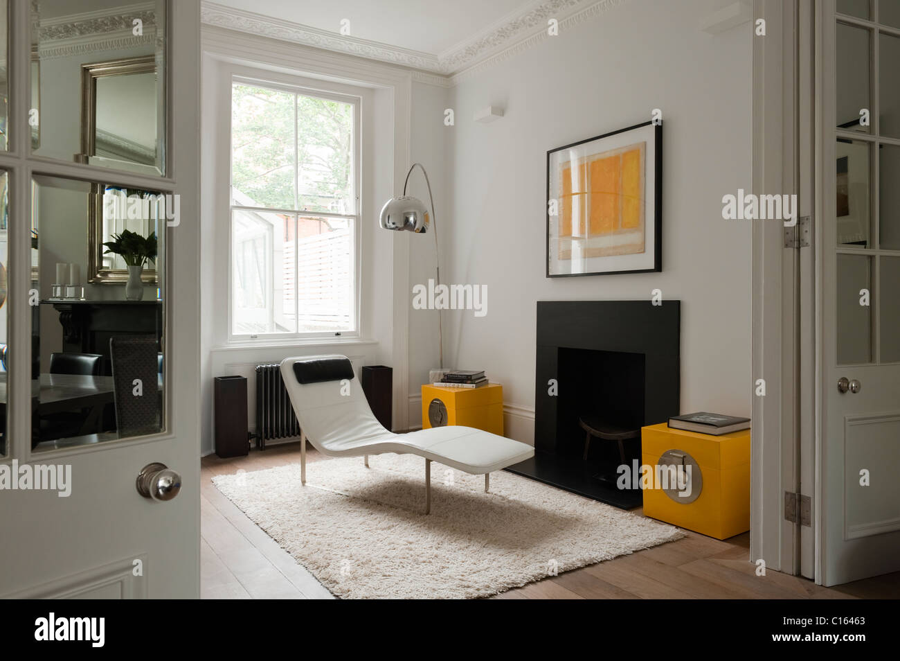 Lounger and arco lamp in room with yellow accent in 19th century Kensington home Stock Photo