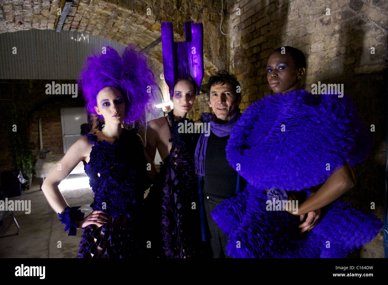 Designer Pierre Garroudi poses with models for a portrait backstage before exhibiting his autumn 2011 collection at his London Stock Photo