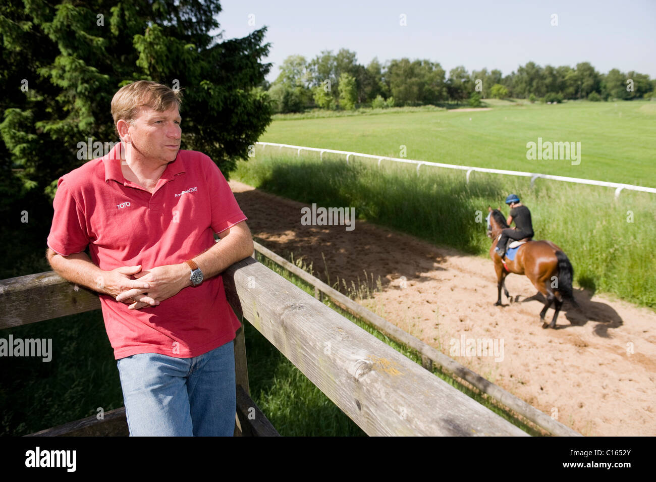 Racehorse trainer Werner Glanz observing his jockeys during training on the training track of Munich Racecourse in Munich-Riem Stock Photo