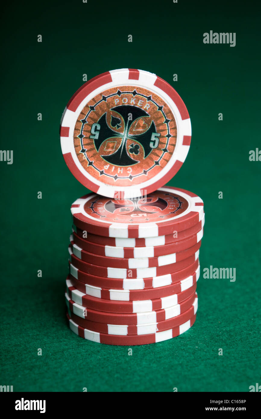 Red poker chips, stacked on green felt Stock Photo