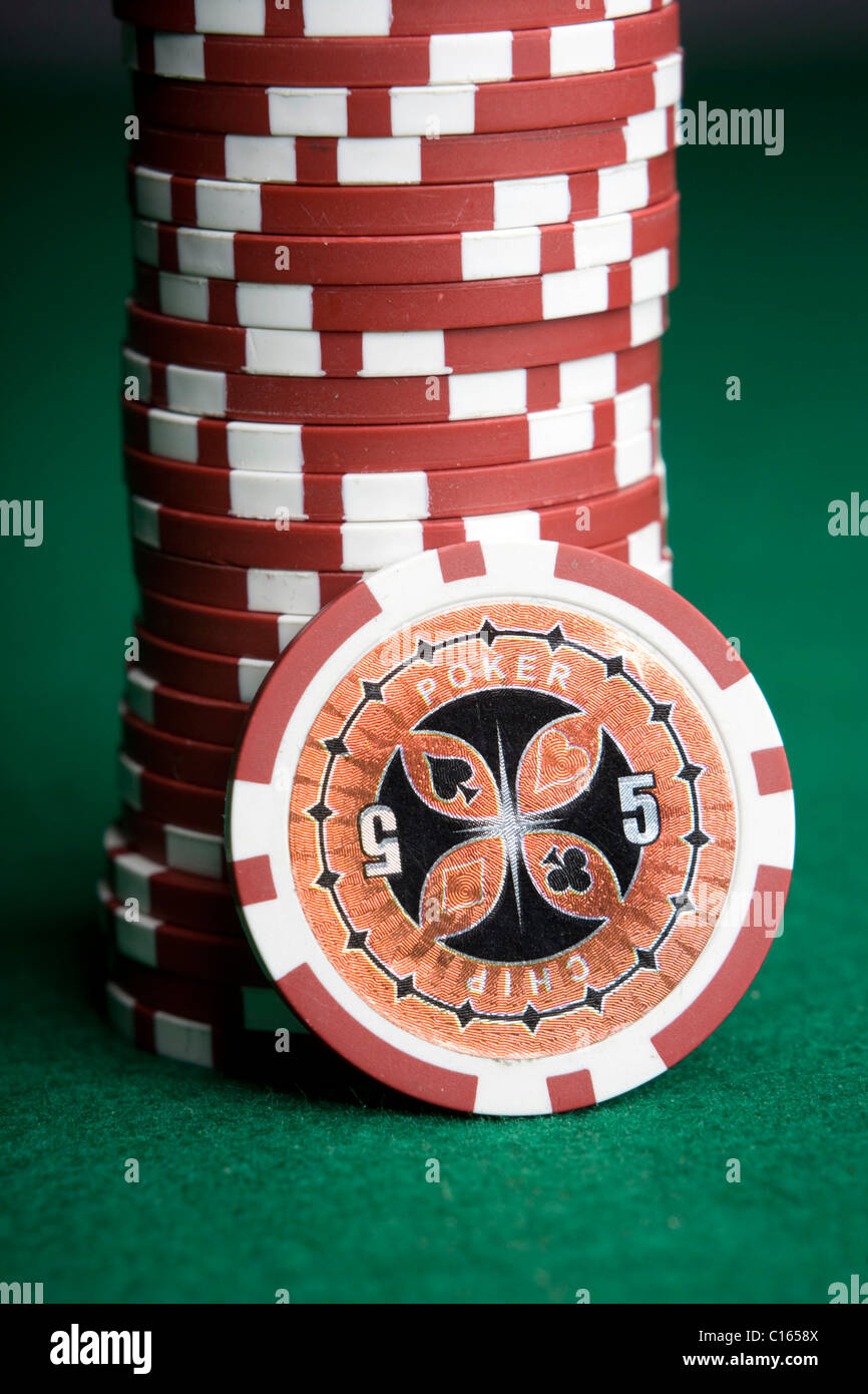 Red poker chips, stacked on green felt Stock Photo