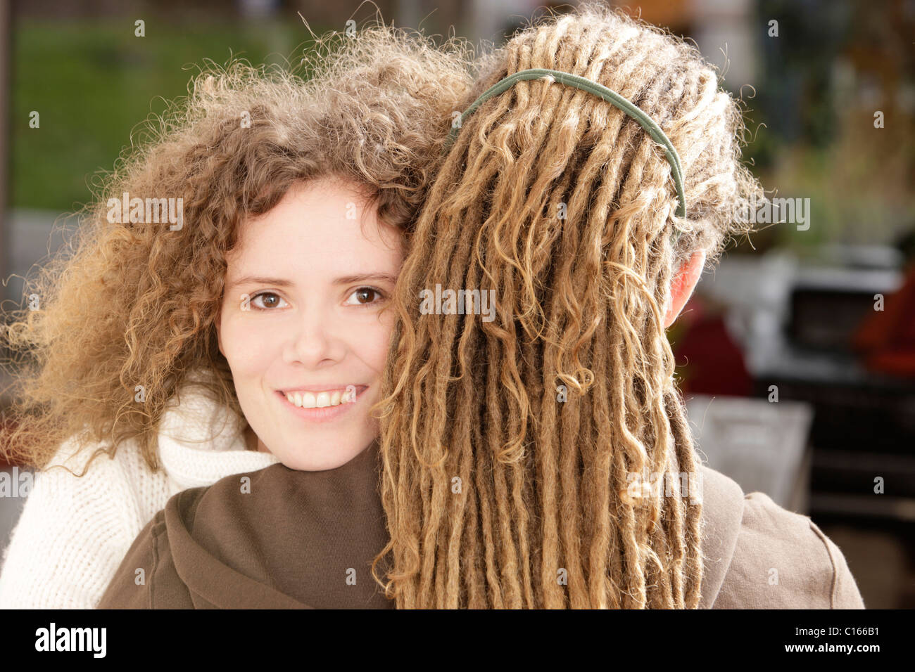 Woman With Curly Hair Smiling And A Man With Dreadlocks