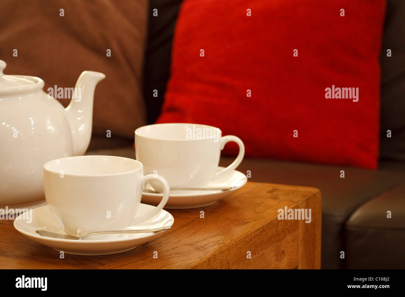 Teapot and cups in a contemporary lounge setting Stock Photo