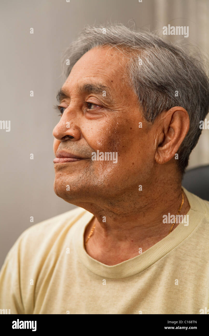 Portrait of old Indian Asian man seated in casual dress Stock Photo