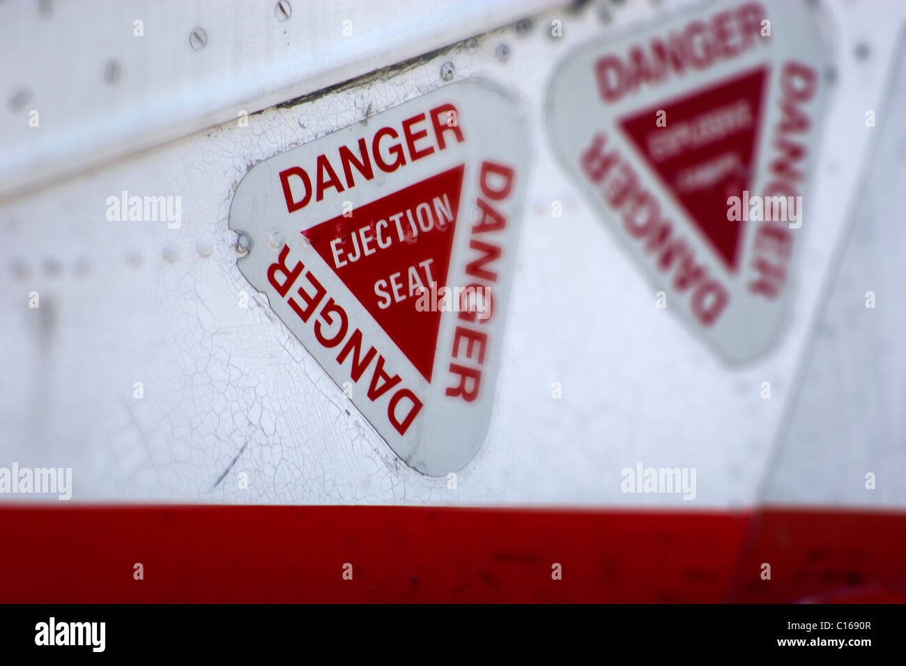 Danger ejection seat signs stickers warnings triangles battered worn damaged red white aircraft jet provest Stock Photo
