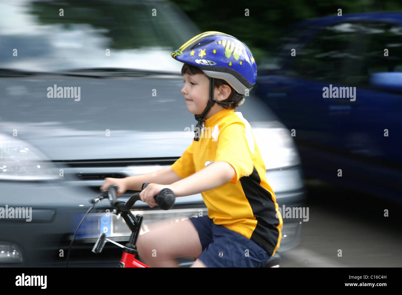 Five-year-old boy wearing a bicycle helmet riding a bike Stock Photo